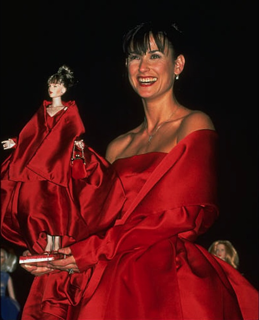 Moore holds her lookalike doll aloft at the AmFar Auction. Courtesy of DOLLS magazine archive